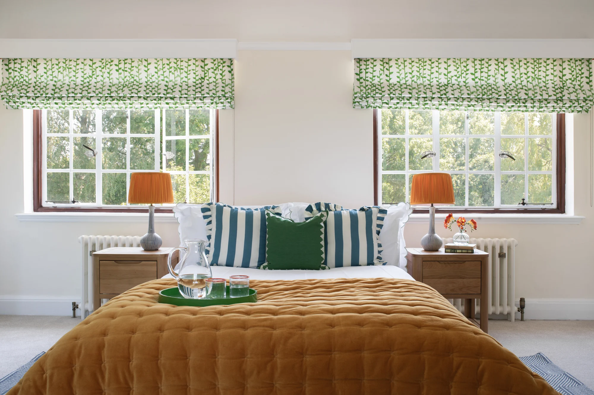 Garden‑inspired interior design bedroom with patterned blinds, deep mustard throw and matching pendant lamps