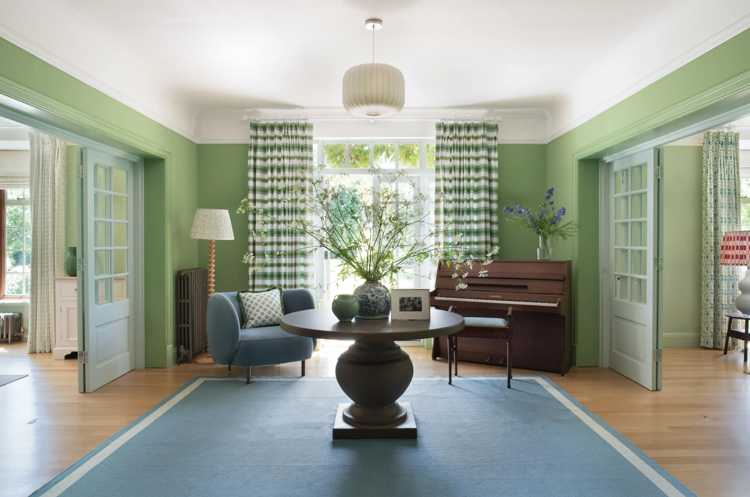 Garden‑inspired interior design entrance hall featuring botanical wallpaper, sculptural mirror, and natural wood console table—bright, welcoming, and elegant.