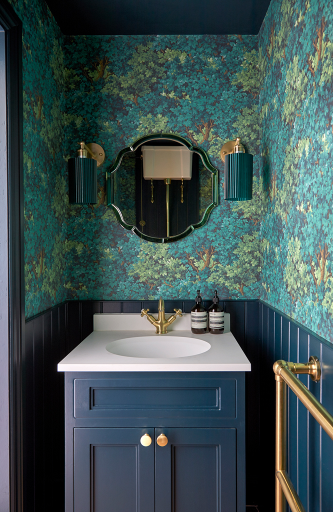Luxurious downstairs cloakroom designed by Kate Lovejoy Interiors in Maidenhead, featuring deep blue cabinetry, gold fittings, and bold botanical wallpaper from the Transformed Family Home project.