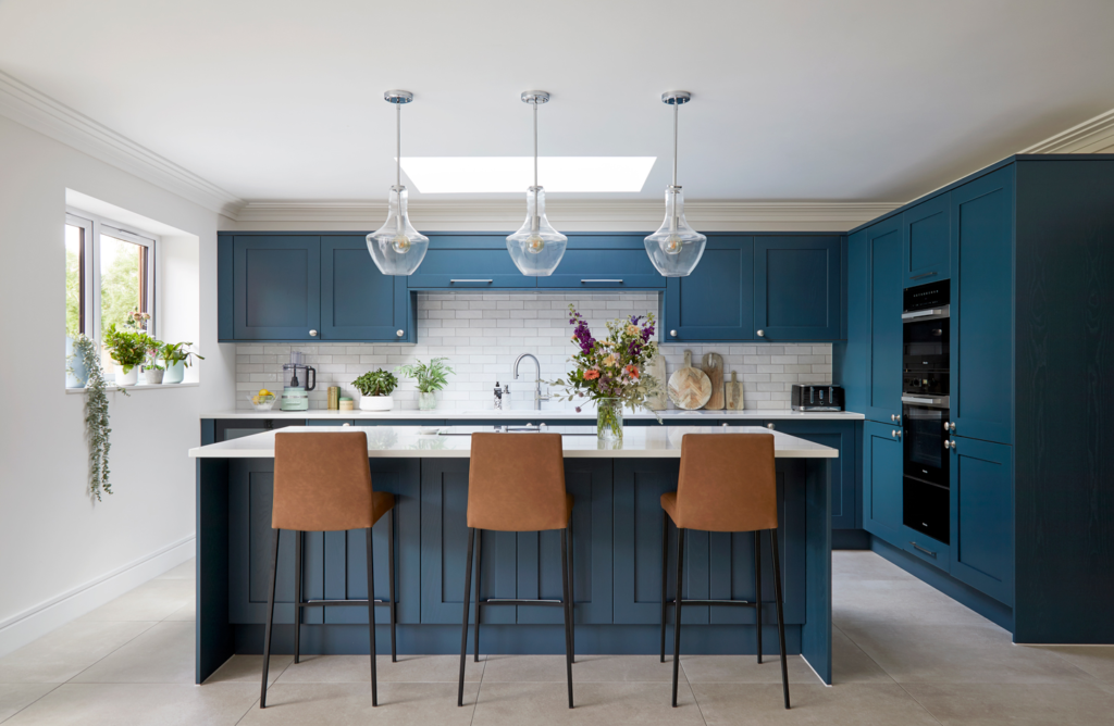 Deep blue island with walnut stools and warm pendant lighting, your inspiration for blue kitchen ideas